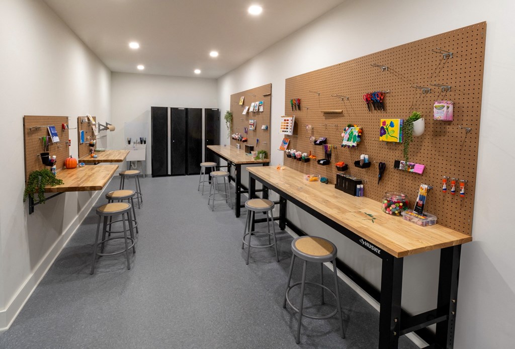a bar with wooden tables and stools in a room with other tables and chairs
