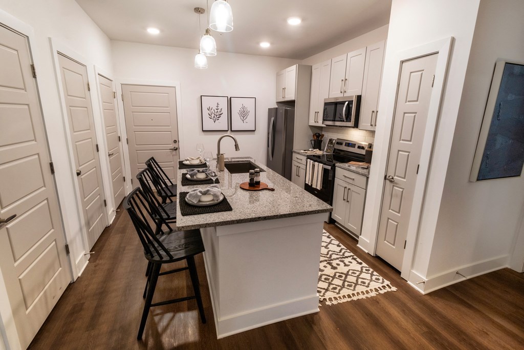 an open kitchen and dining area with a granite counter top