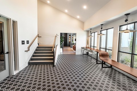 a living room with a staircase and a black and white tile floor