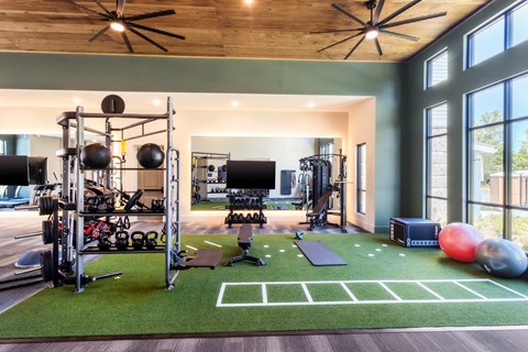 a home gym with weights and equipment and large windows