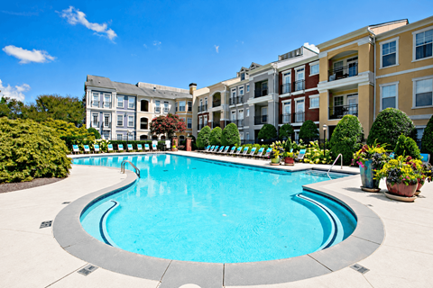 A swimming pool in front of apartment buildings.