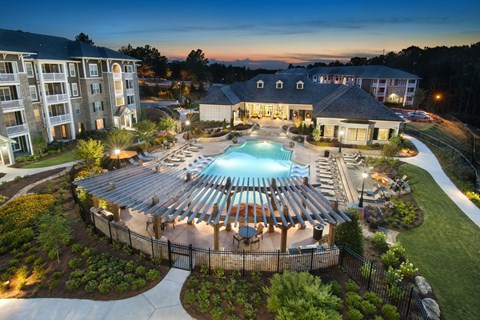 A large building with a pool in the middle of a courtyard surrounded by a fence.