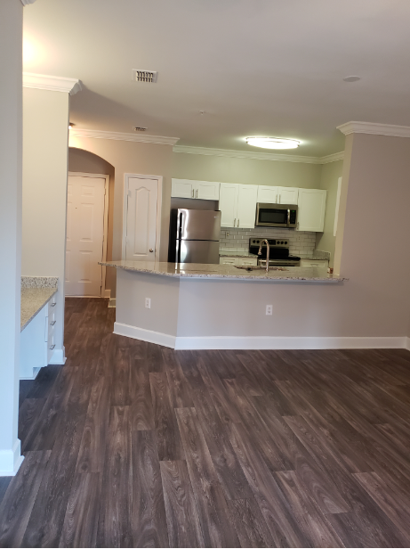 an empty kitchen and living room with hardwood floors