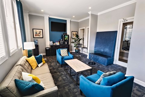 A living room with a grey couch and blue chairs.