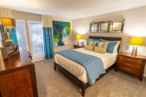 a bedroom with a bed and a dresser and a window