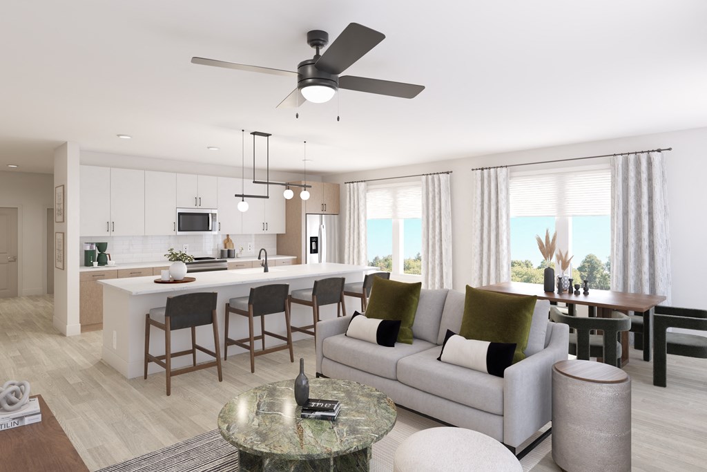 A modern living room with a kitchen area in the background.