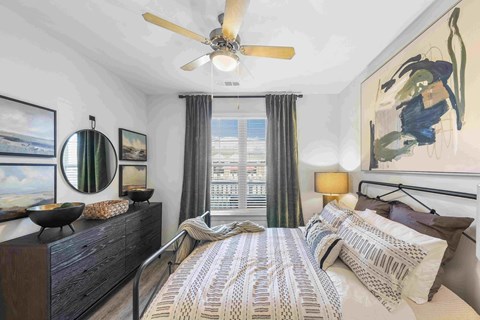 A bedroom with a large bed and a painting on the wall.