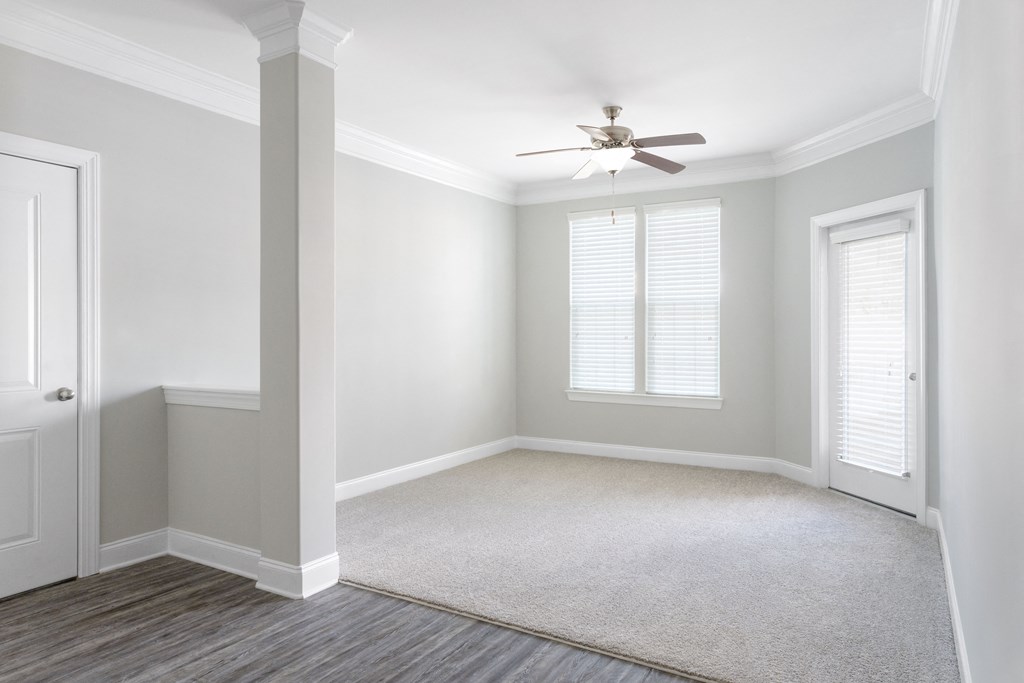 an empty room with a ceiling fan and two doors