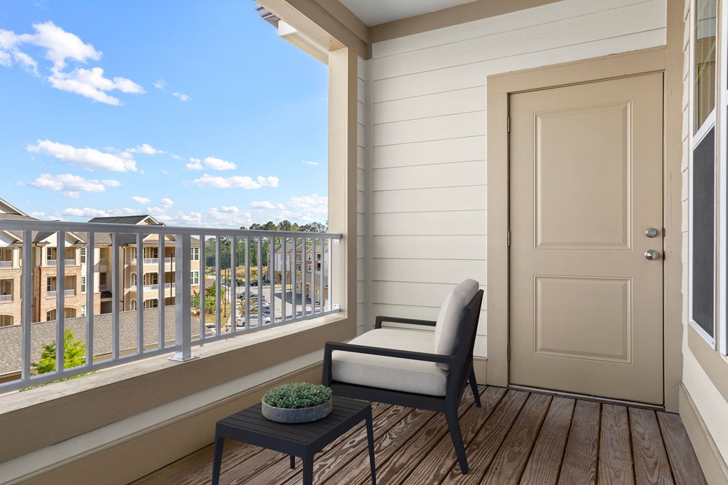 a balcony with a chair and a small table