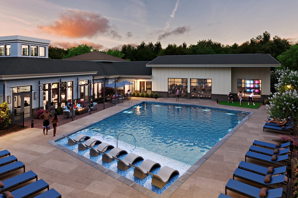 an aerial view of a swimming pool with lounge chairs and a building in the background