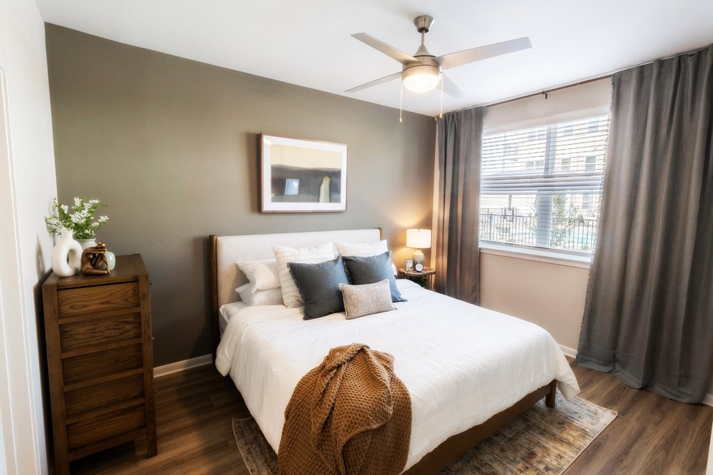 a bedroom with a large white bed and a ceiling fan
