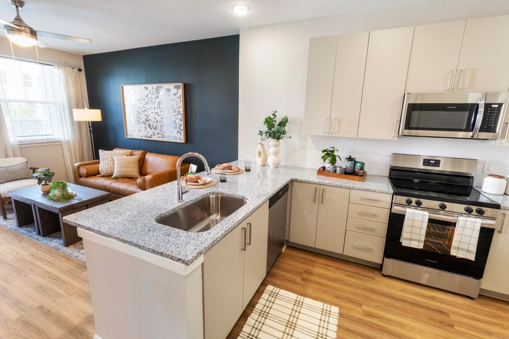 an open kitchen and living room with a granite counter top