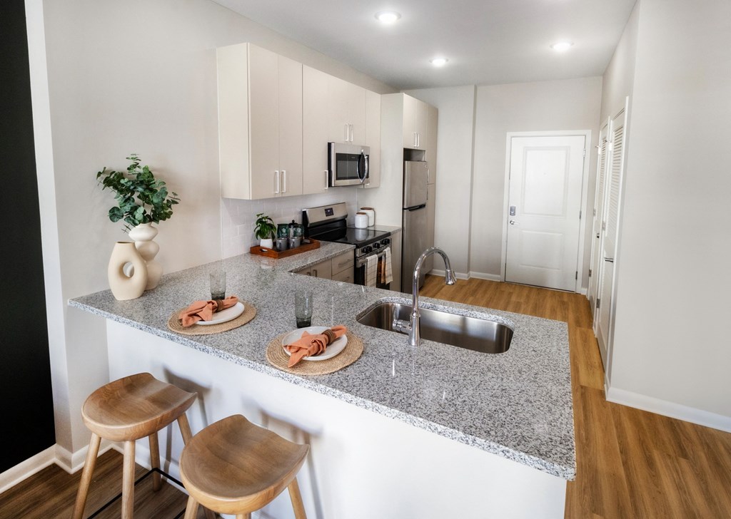 an open kitchen with a granite counter top and a sink