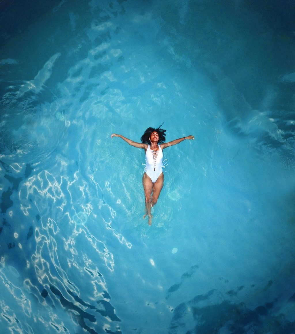 a woman laying in the water in a pool