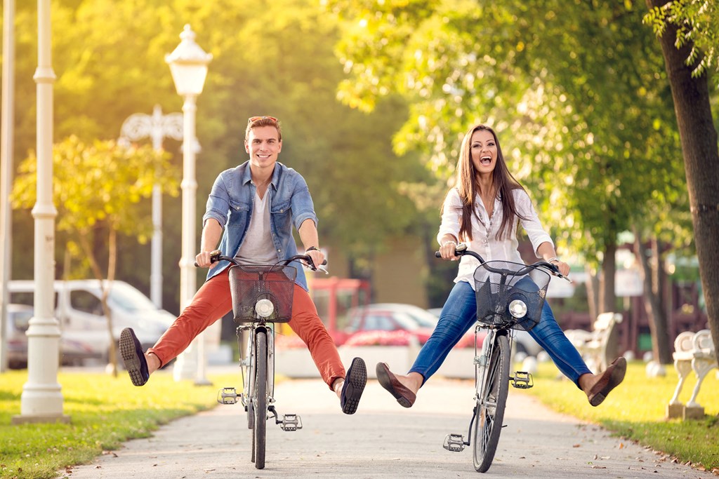 a man and woman riding bikes with their legs in the air