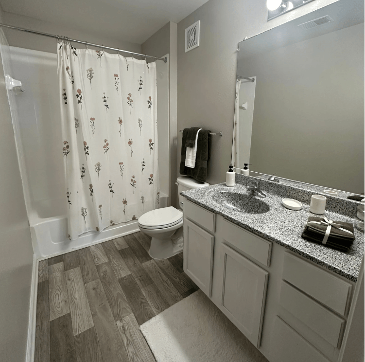 A bathroom with a toilet, sink, and shower curtain. at The Dawson Cartersville in Cartersville, GA 30191