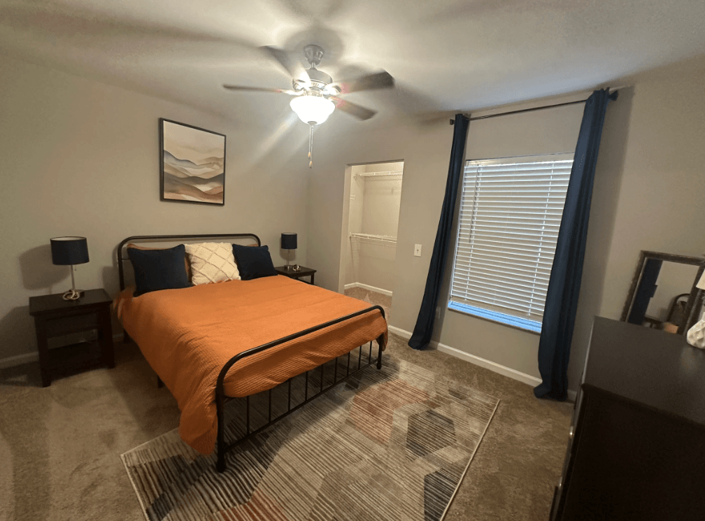 A bedroom with a bed, nightstands, and a ceiling fan. at The Dawson Cartersville in Cartersville, GA 30191