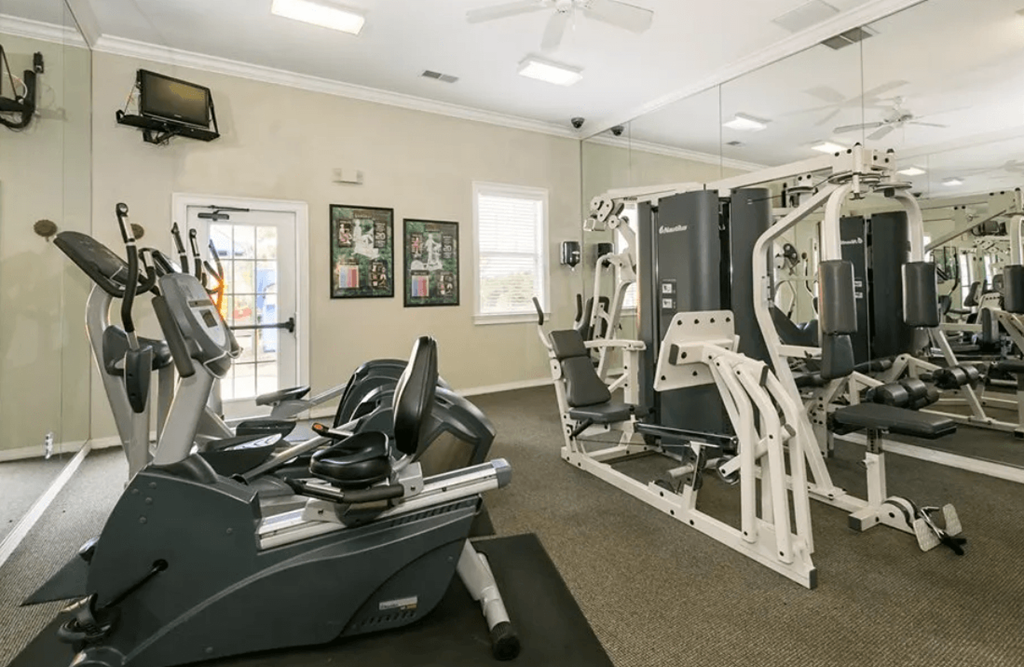 A gym with a variety of equipment including treadmills, weights, and a television. at The Dawson Cartersville in Cartersville, GA 30191