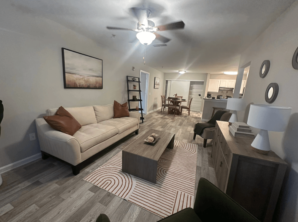 A living room with a couch, coffee table, and a ceiling fan. at The Dawson Cartersville in Cartersville, GA 30191