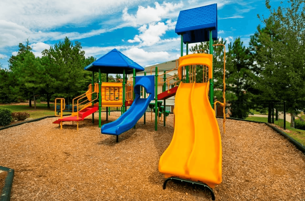 A playground with a yellow slide and a blue roofed structure. at The Dawson Cartersville in Cartersville, GA 30191