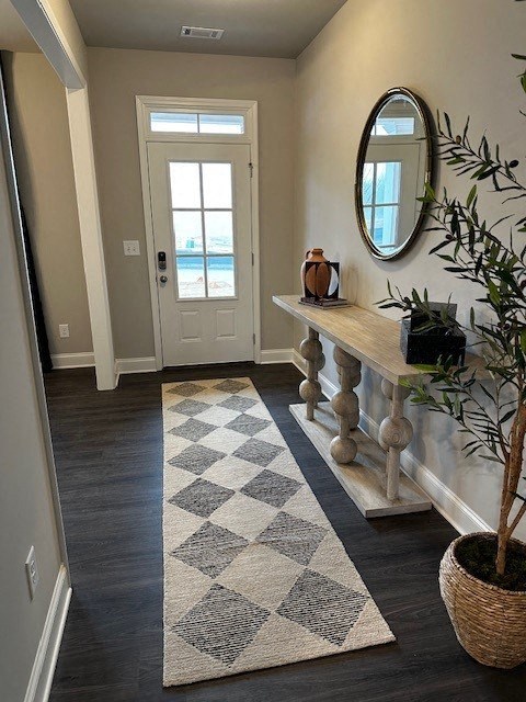 a hallway with a checkered rug and a white door