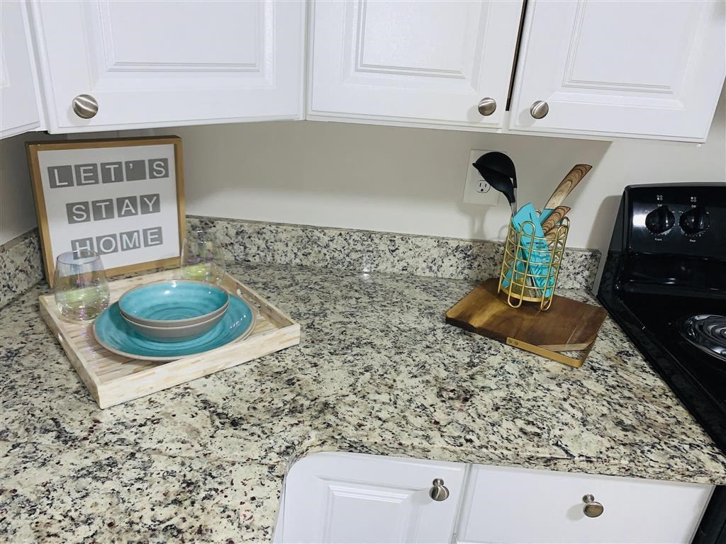 a kitchen with white cabinets and a counter top