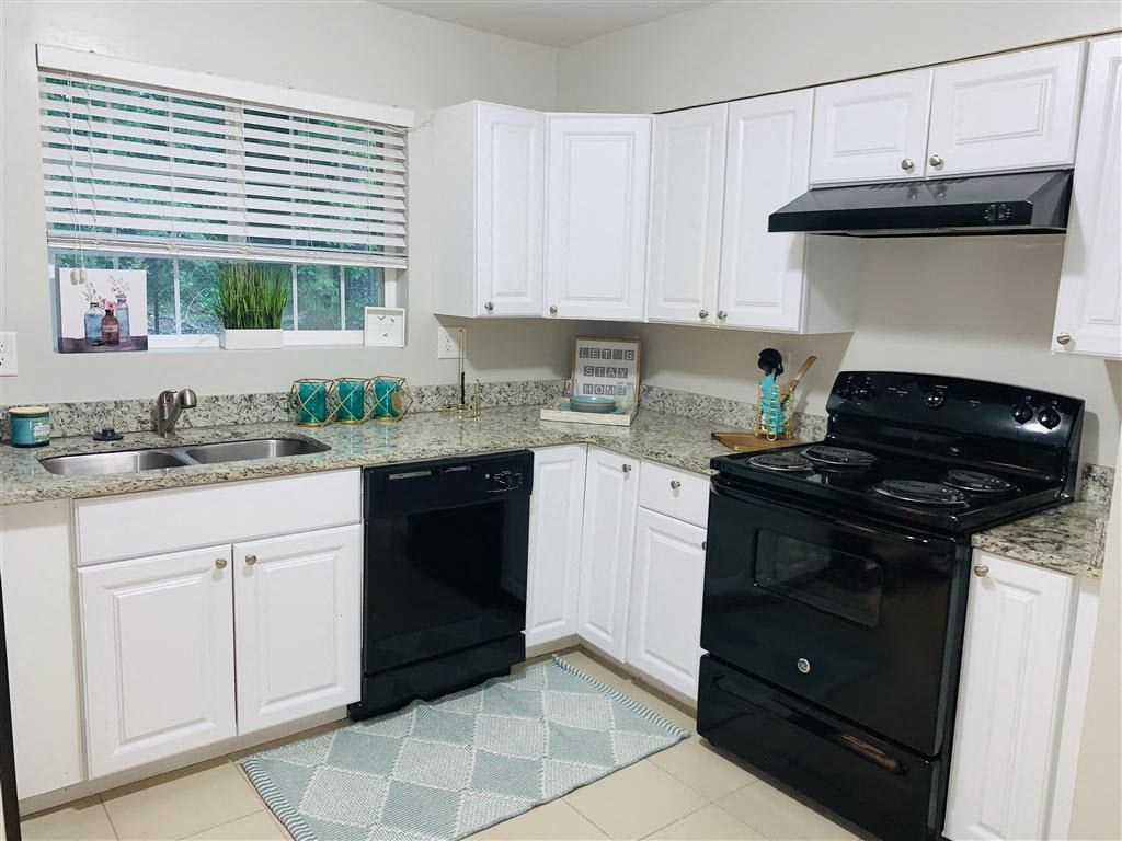 a kitchen with black appliances and white cabinets