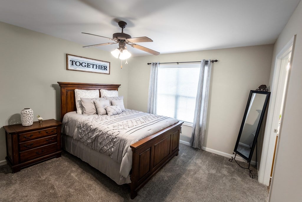 a bedroom with a bed and a ceiling fan