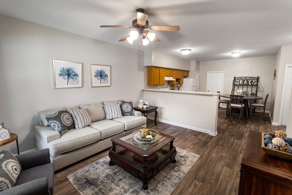 a living room with a couch coffee table and a kitchen in the background