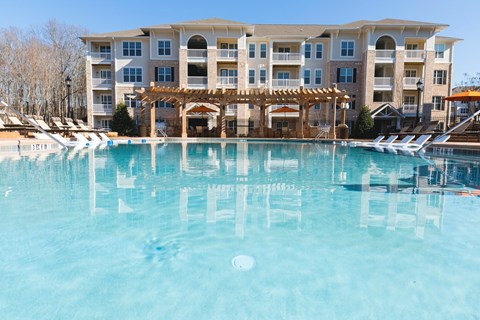 A large building with a pool in front of it.