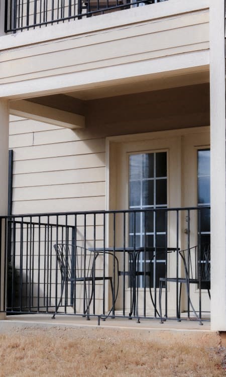 a patio with chairs and a table on a balcony