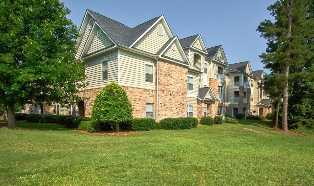 a large green lawn in front of an apartment building