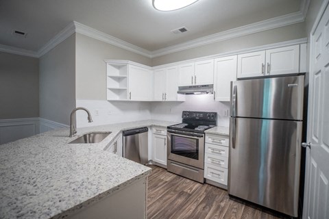 a kitchen with white cabinets and stainless steel appliances