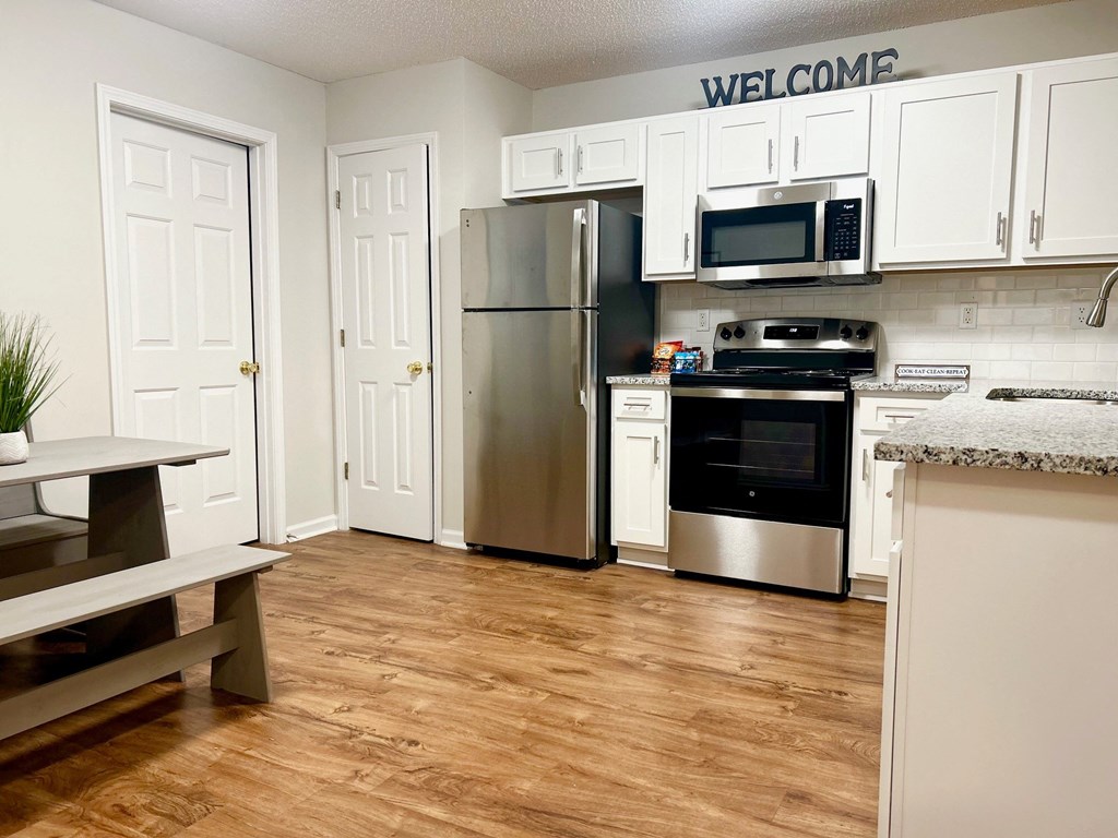 a kitchen with white cabinets and stainless steel appliances