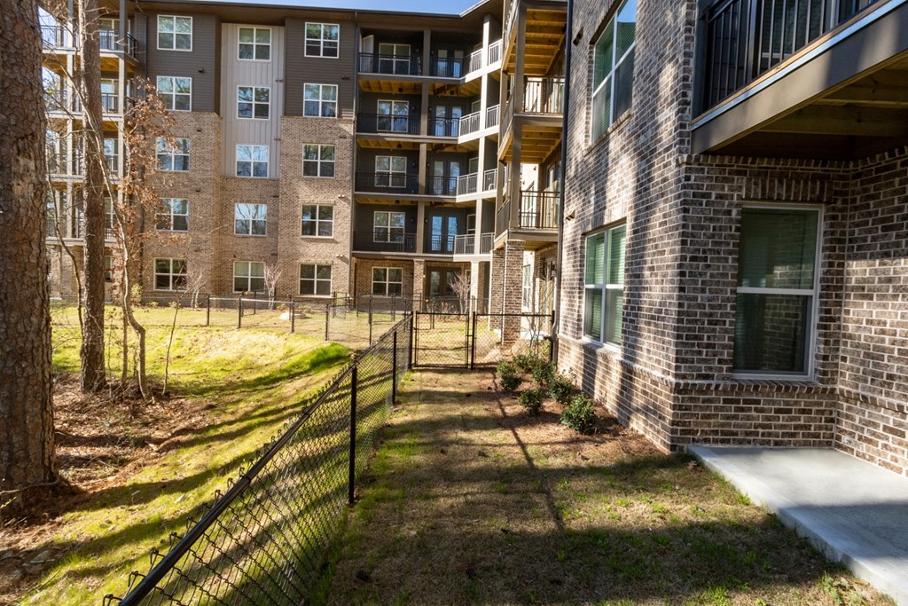 a fenced in yard in front of an apartment building