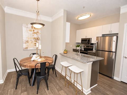 A kitchen with a table and chairs in the middle of the room.