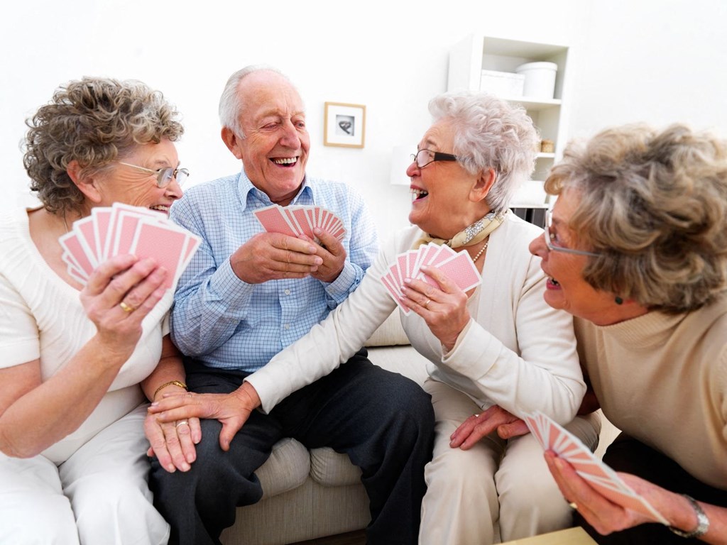 a group of people sitting on a couch playing cards