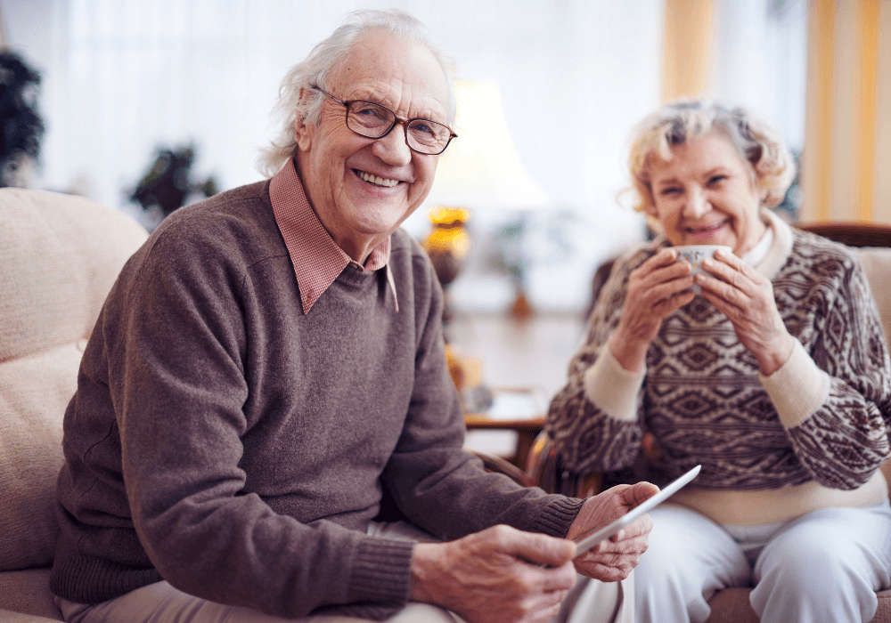 an older man and woman sitting on a couch