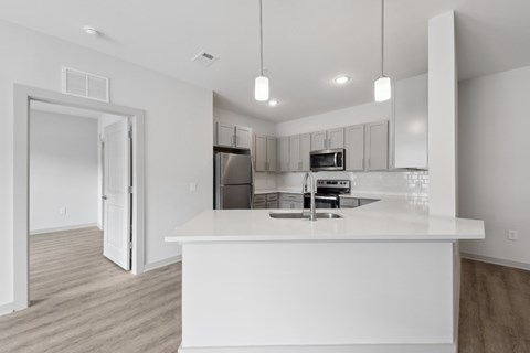 A white kitchen with a sink and a refrigerator.