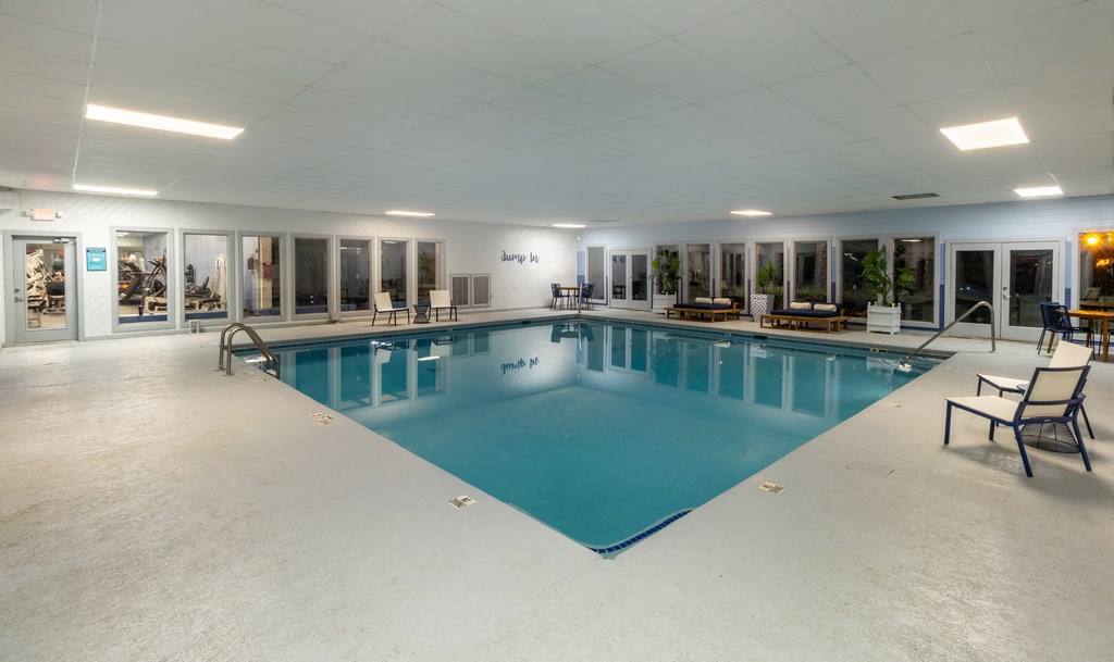 a large indoor swimming pool with lounge chairs and tables at Seven Pines, Alpharetta, GA