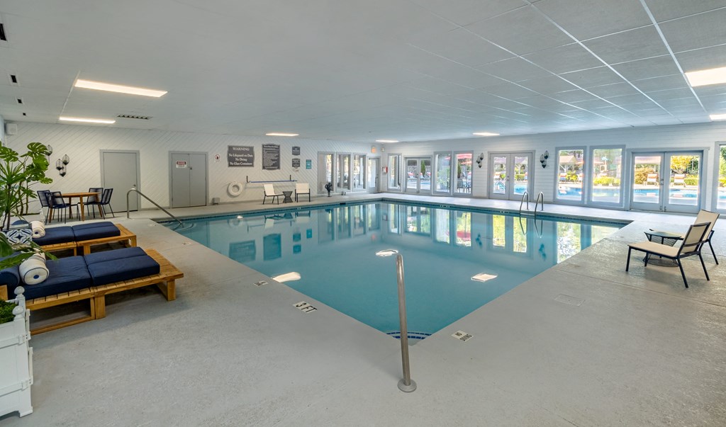 a large indoor swimming pool with lounge chairs and tables at Seven Pines, Alpharetta, GA