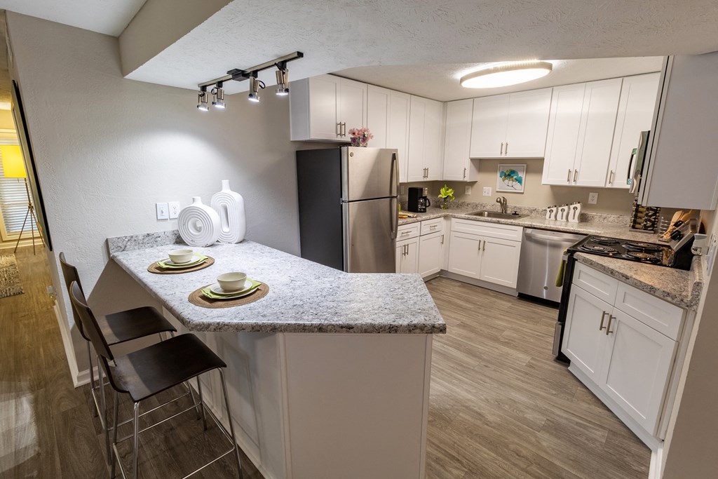 a kitchen with white cabinets and stainless steel appliances at Seven Pines, Alpharetta, GA