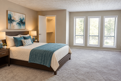 A bedroom with a large bed and a painting on the wall.