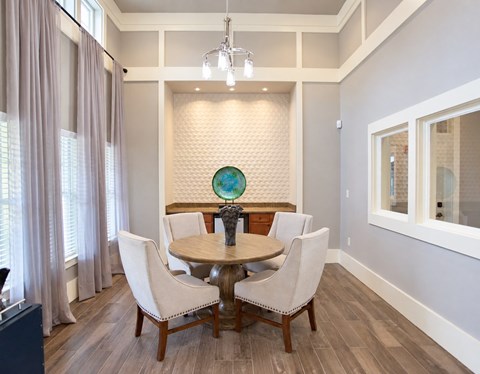 A dining room with a round table and chairs.