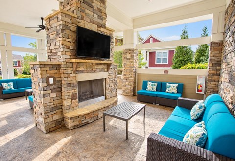 A stone fireplace with a flat screen TV above it.