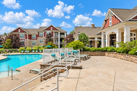 A pool area with a slide and a building in the background.