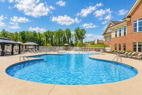 A large outdoor swimming pool with a building in the background.