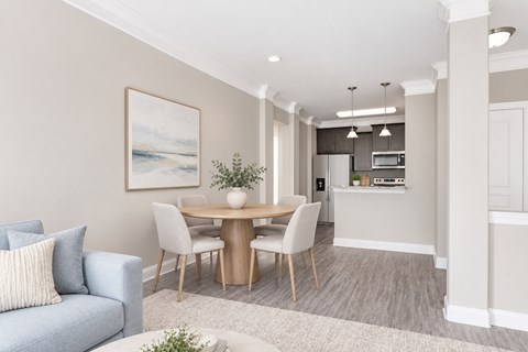 A modern dining room with a blue couch and a wooden table.
