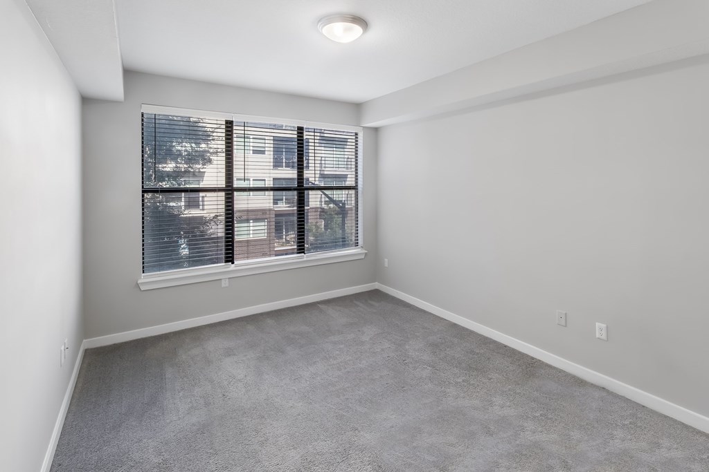 A room with a window and a view of a building outside.