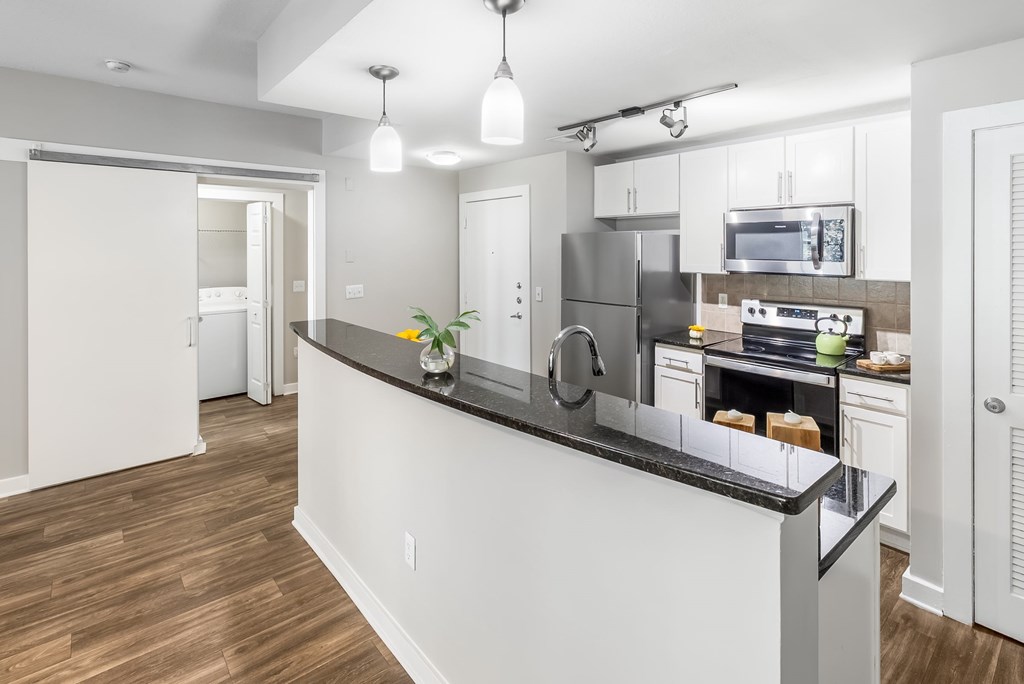 A modern kitchen with a white island and stainless steel appliances.
